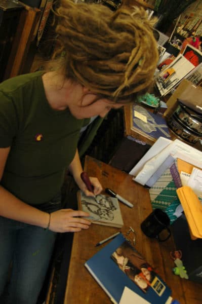 Bethany Taylor carving image of herself and her son into linoleum block-brighter